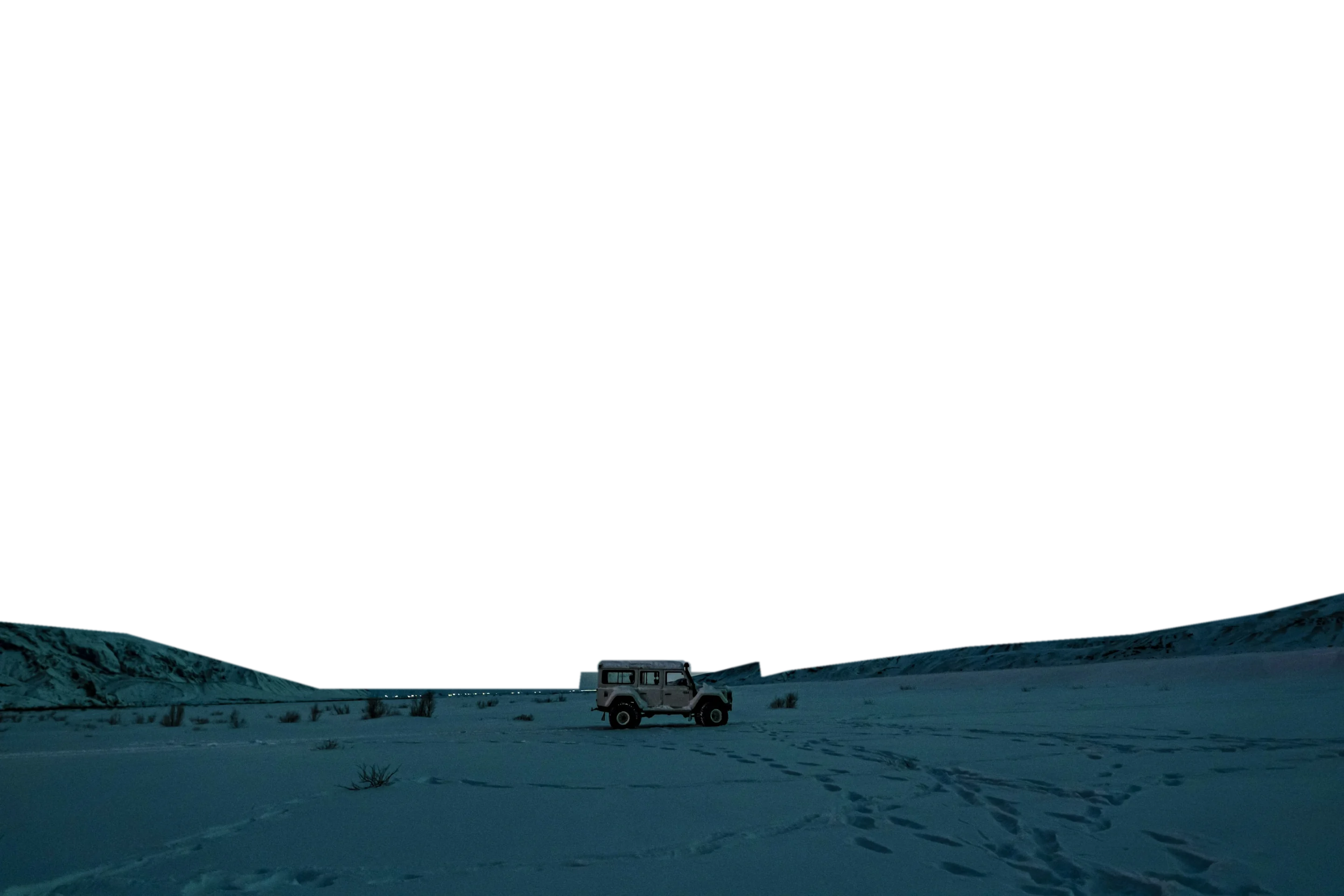 A four-wheel-drive vehicle on snow under green northern lights