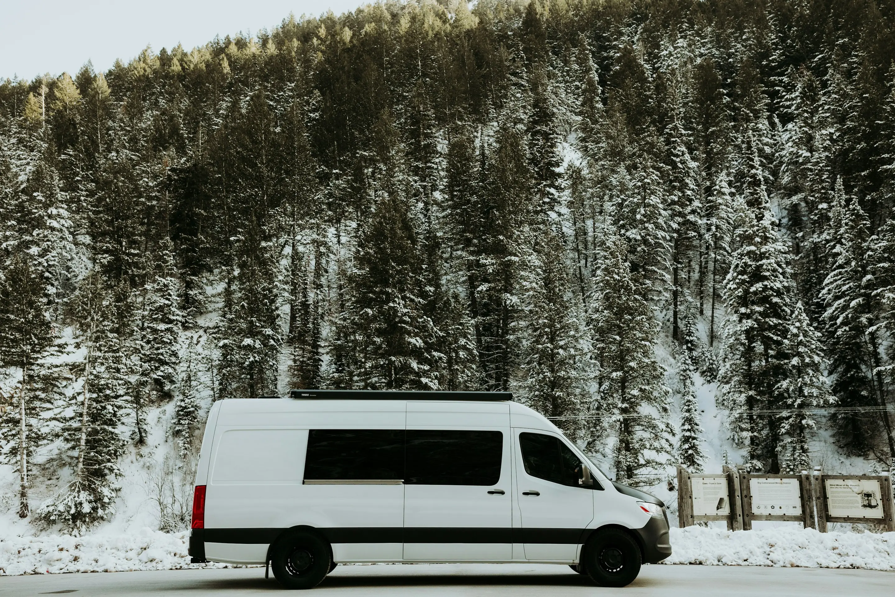A white Mercedes-Benz Sprinter van on a snowy road
